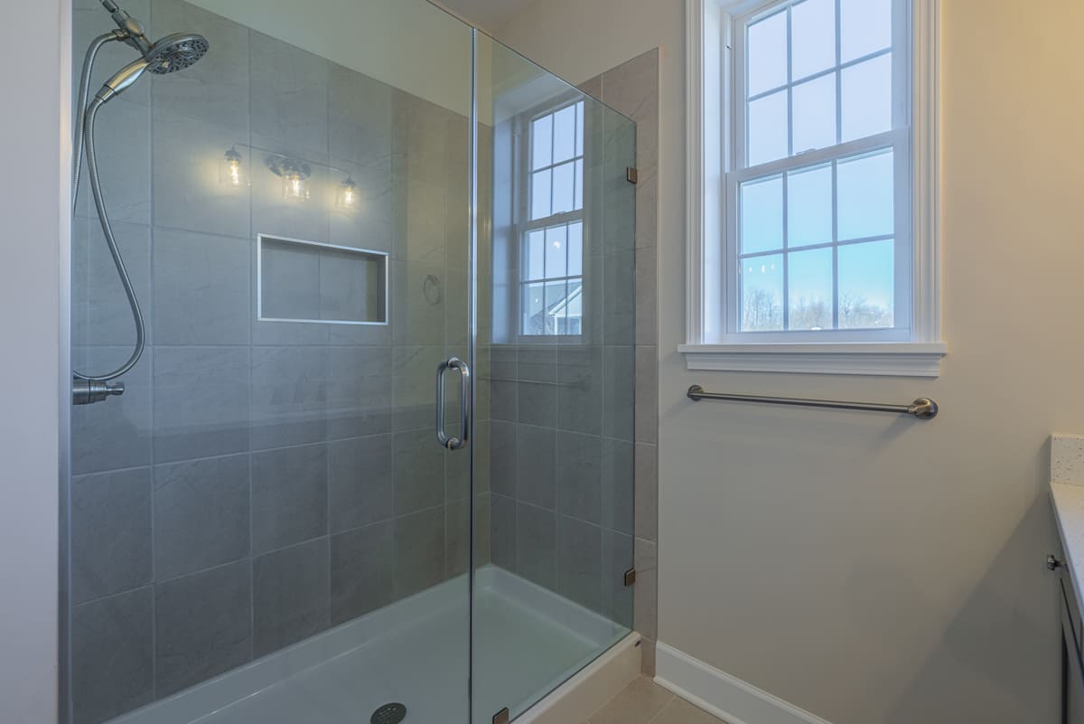 Walk-in shower with inset shelving and window in The Cottages of Canandaigua near Rochester